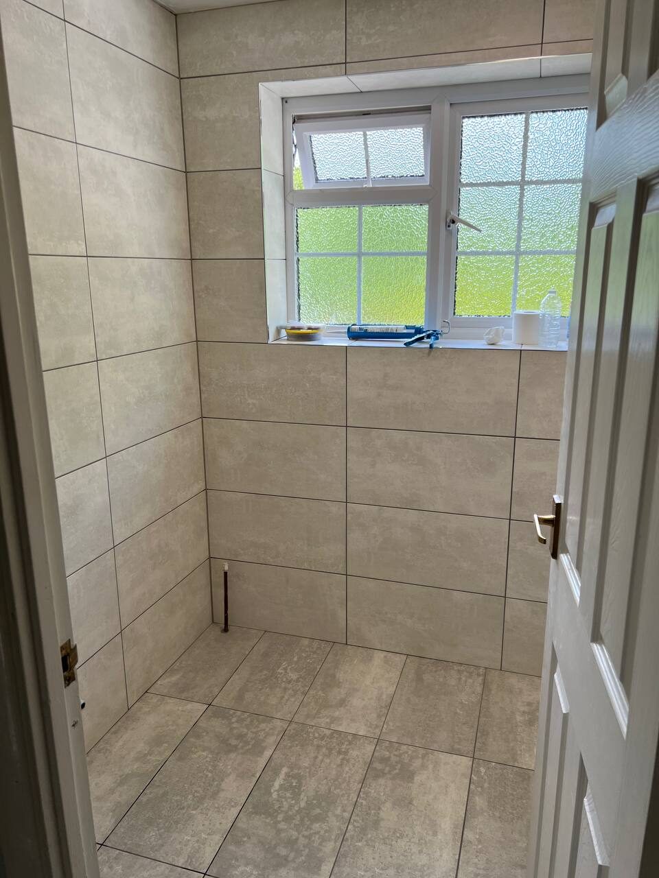 Walls and floor fully tiled in stone-effect porcelain before fittings go in