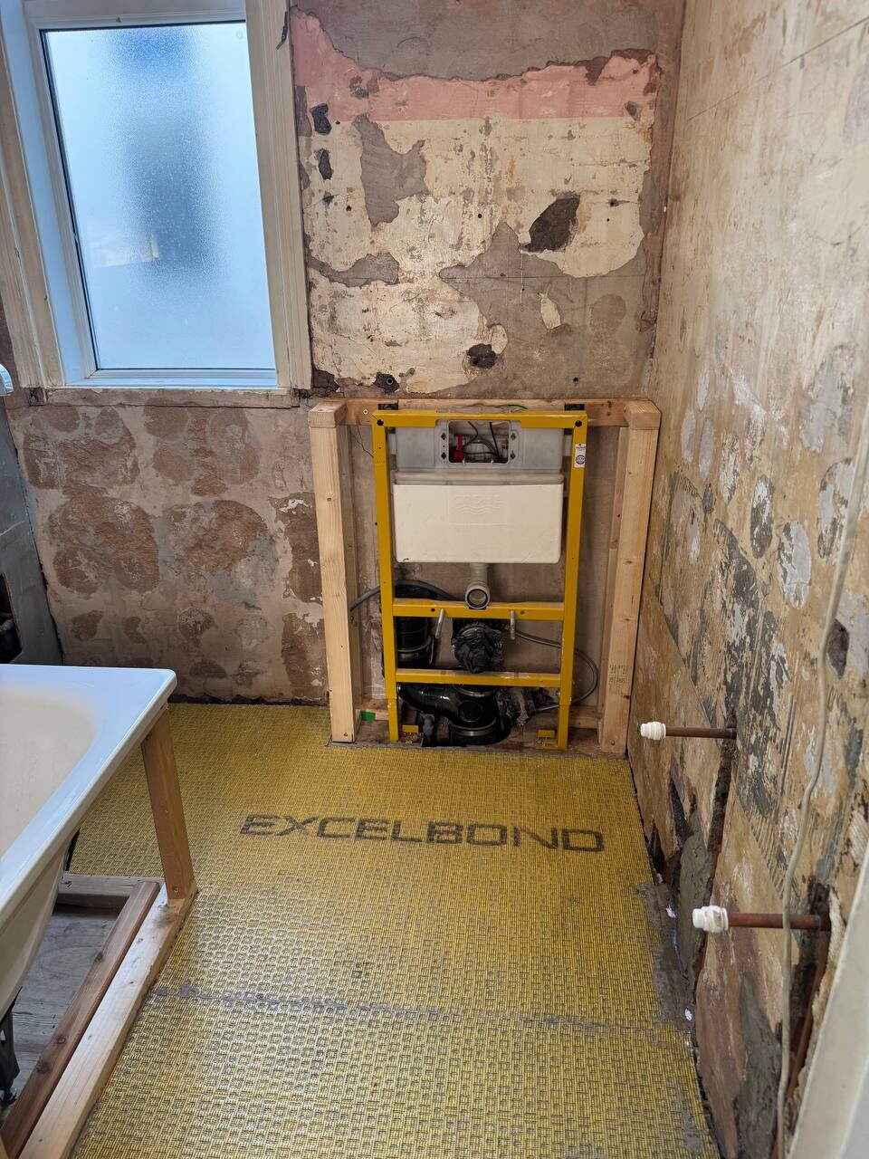 Bathroom taken back to brick with a concealed cistern frame built into the stud wall