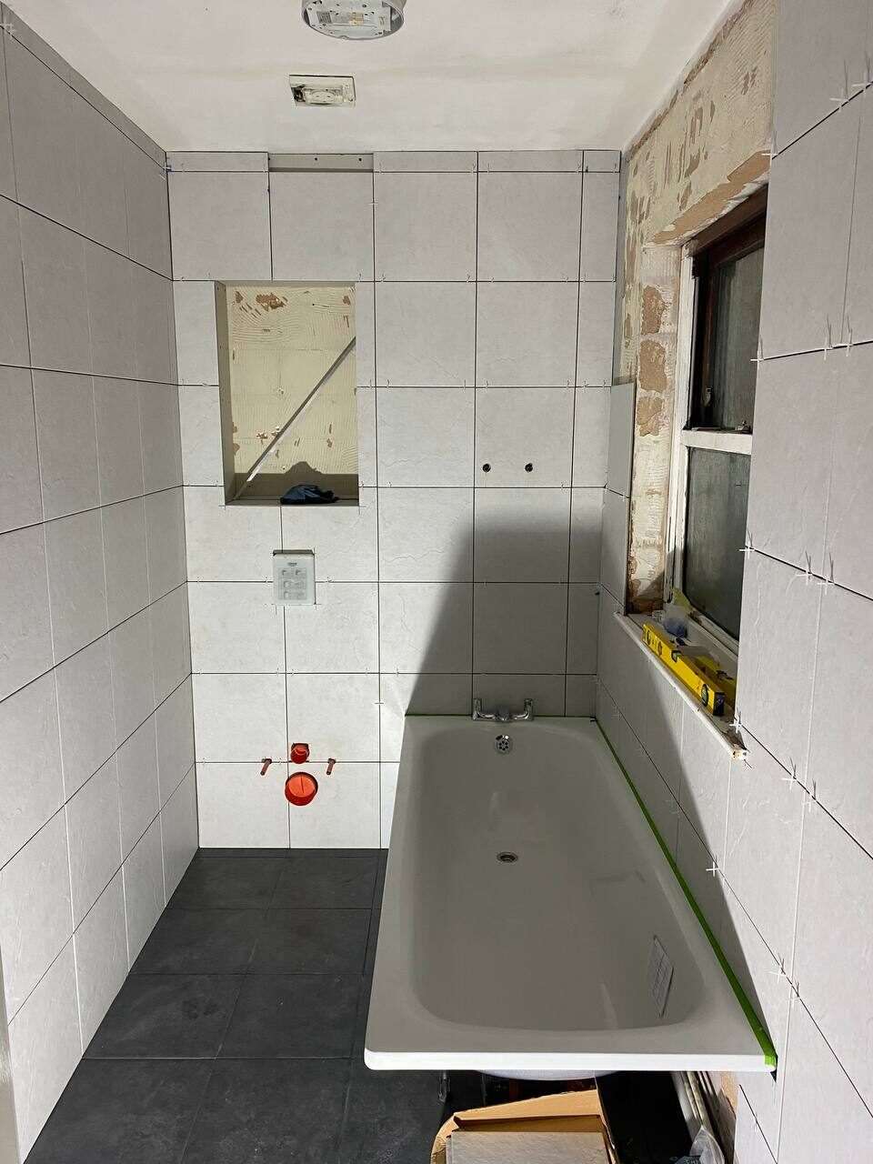Tiling underway with the concealed cistern boxed in