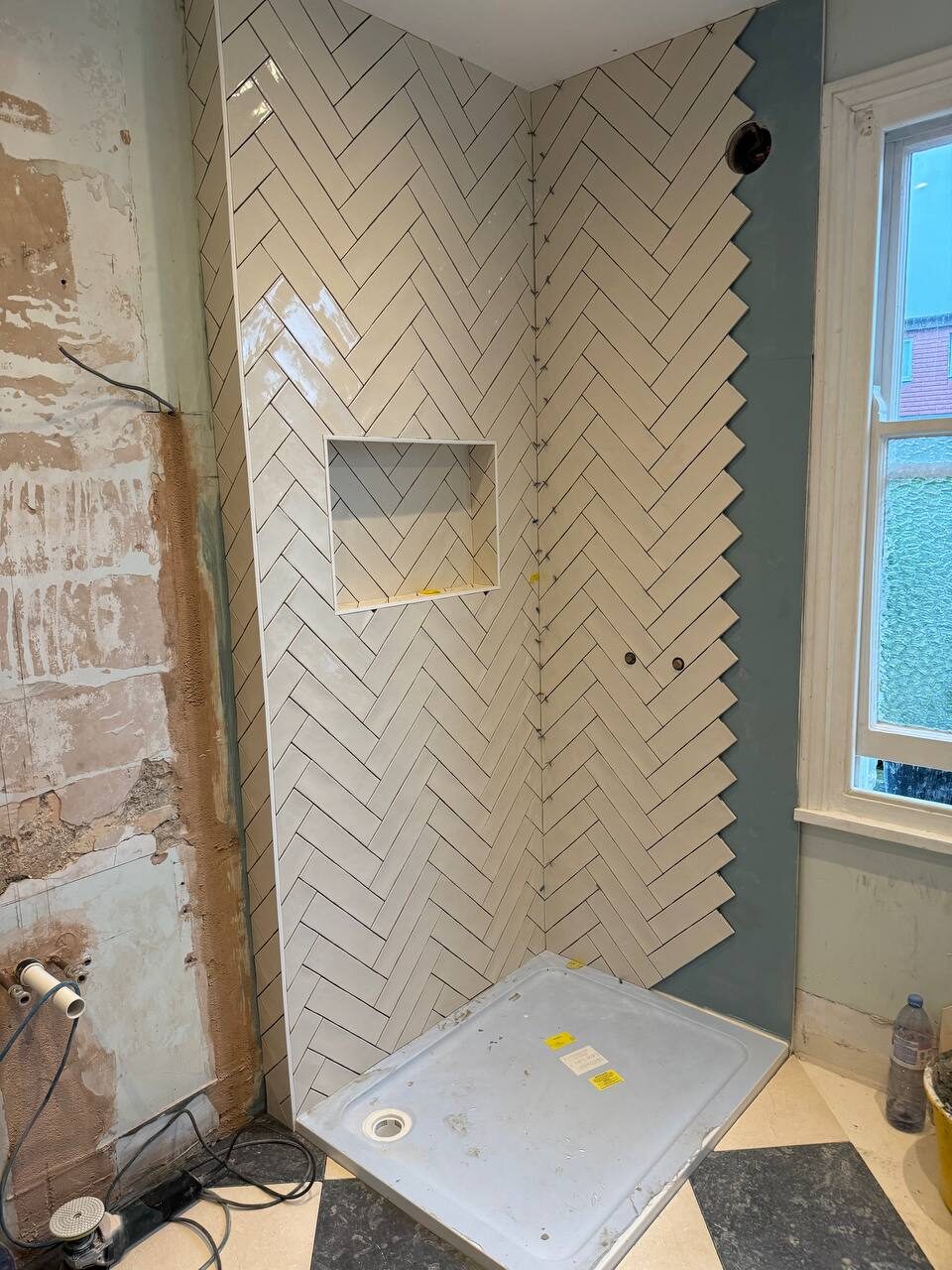 Herringbone-tiled shower enclosure with recessed niche and tray set